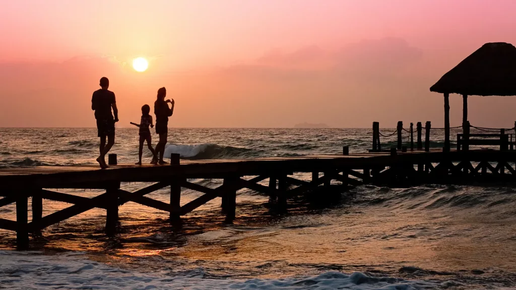 Familie im Urlaub am Meer mit Sonnenuntergang